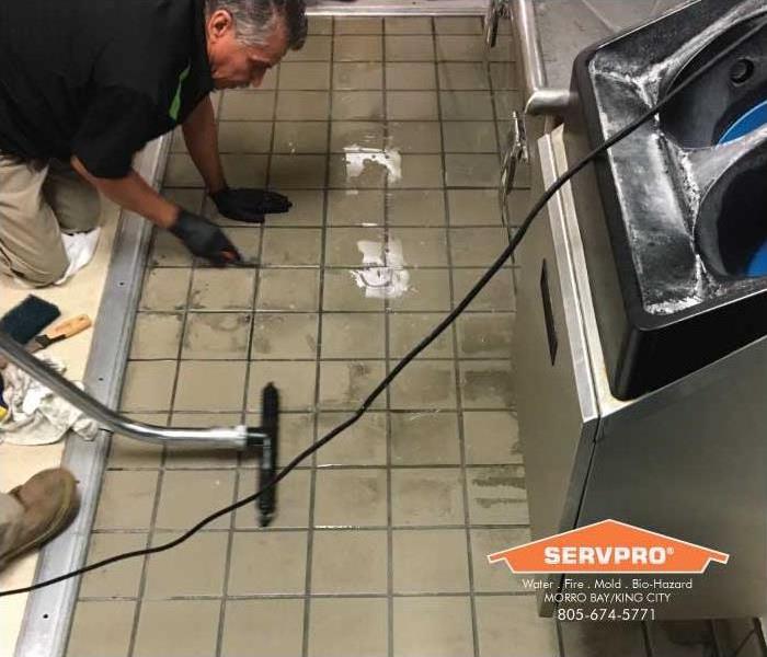 a picture of a technician cleaning grout
