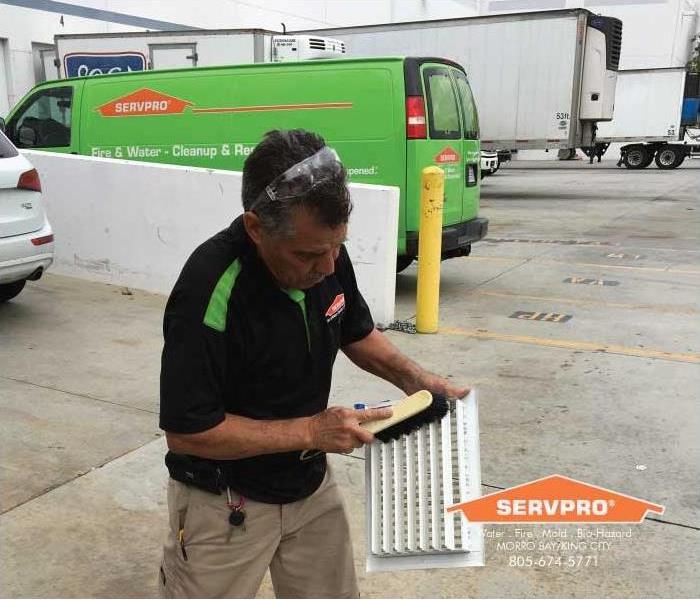 a picture of a man cleaning a office vent